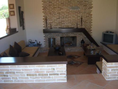 a living room with a fireplace and a couch at Luxury Villa Flora Kiparissia in Kyparissia