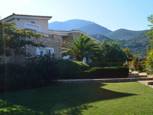 a house with a garden and mountains in the background at Luxury Villa Flora Kiparissia in Kyparissia