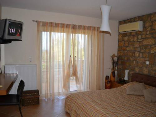 a bedroom with a bed and a desk and a television at Luxury Villa Flora Kiparissia in Kyparissia