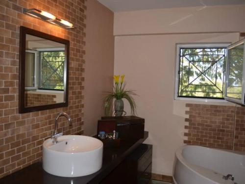 a bathroom with a sink and a tub and a mirror at Luxury Villa Flora Kiparissia in Kyparissia