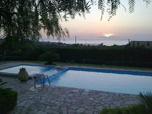 a swimming pool with a vase sitting next to it at Luxury Villa Flora Kiparissia in Kyparissia