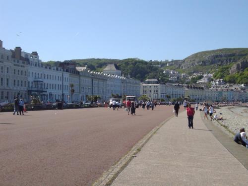 a group of people walking down a street with buildings at THE TREVONE, Llandudno in Llandudno