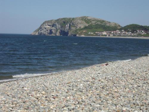 a rocky beach with an island in the water at THE TREVONE, Llandudno in Llandudno