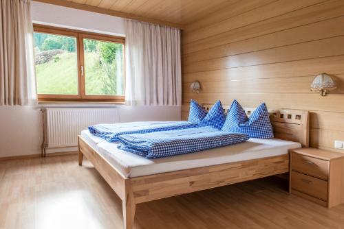 ein Schlafzimmer mit einem Bett mit blauen Kissen darauf in der Unterkunft Haus Silberberg in Bartholomäberg