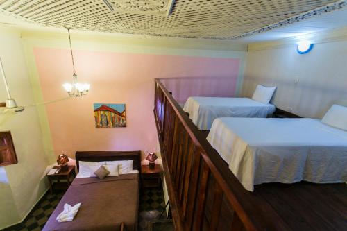 a hotel room with two beds and a balcony at Hotel Casa del Consulado in Granada