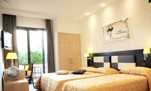 ポンペイにあるHotel Visagiのベッド2台とバルコニーが備わるホテルルームです。