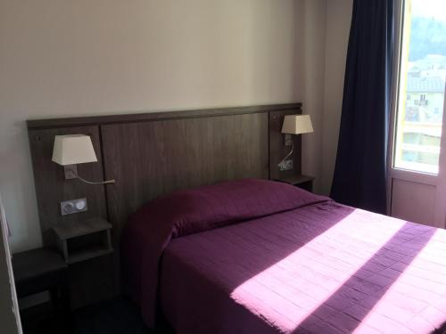 a bedroom with a purple bed and a window at Hôtel Mont-Brison in Briançon