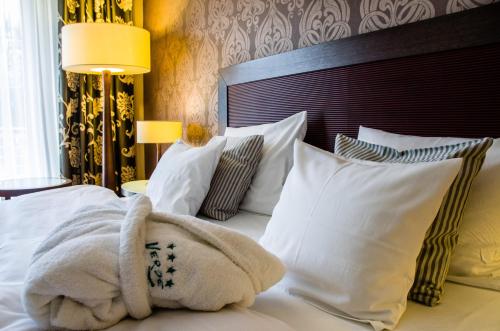 a hotel room with a bed with white pillows at Hotel Verde in Koszalin