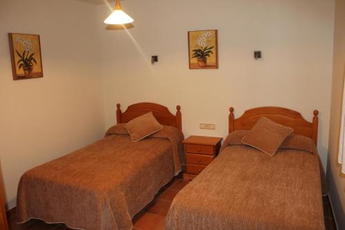 a bedroom with two beds and a night stand at Alojamiento Rural Sierra Luz in Ribatajadilla