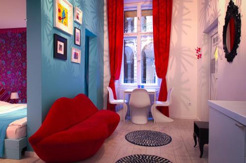 Un dormitorio con una silla roja y una cama en BpR City Center Design Apartments, en Budapest