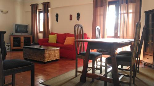 a living room with a table and a red couch at Historic Centre Apartment Cascais in Cascais