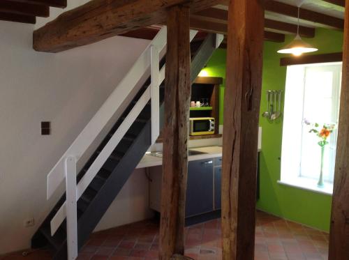 a staircase in a kitchen with green walls at La Cle des Champs in Provency