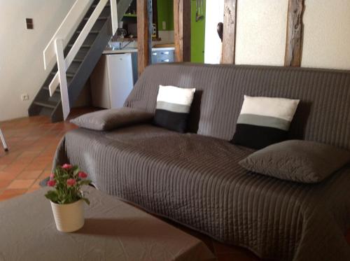 a brown couch with pillows in a living room at La Cle des Champs in Provency