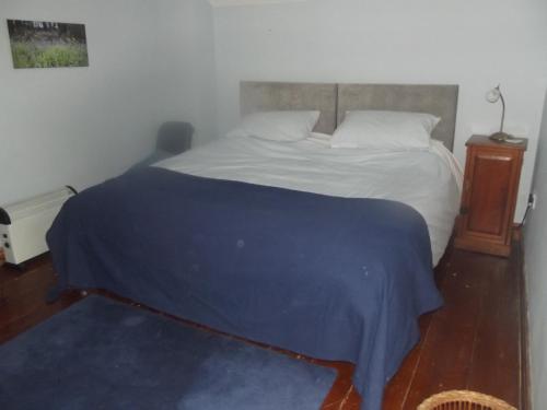a bedroom with a bed with a blue blanket on it at Pleck Barn B&B in Ansty