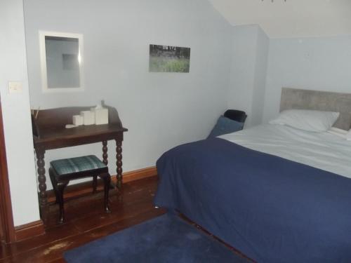 a bedroom with a bed and a desk and a chair at Pleck Barn B&B in Ansty