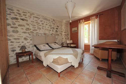 um quarto com uma cama, uma secretária e um piano em La Rialhe em Taulignan