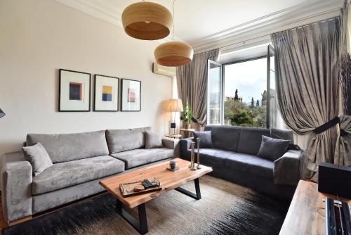 アテネにあるAcropolis Exclusive Residencesのソファとテーブルのあるリビングルーム