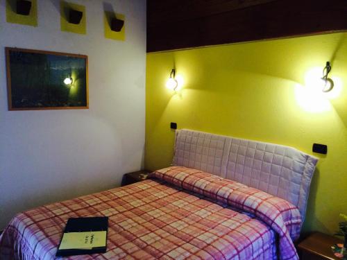 a bedroom with a bed with a book on it at Ca di Voi in Calizzano