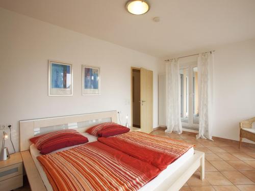 ヴァッサーブルクにあるHaus Hartmann, Ferienwohnungen Sonnenseiteのベッドルーム1室(大型ベッド1台、赤い枕付)