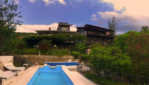 uma casa com piscina em frente a uma casa em Casa Alta Hotel Boutique & Spa - Solo Adultos em Villa Carlos Paz