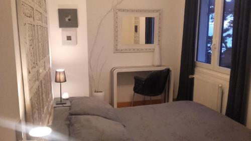 a bedroom with a bed and a chair and a window at Chambres d'hôtes Christa in Saint-Pair-sur-Mer
