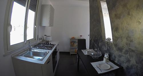 a small kitchen with a sink and a stove at House Etna View in Mascali
