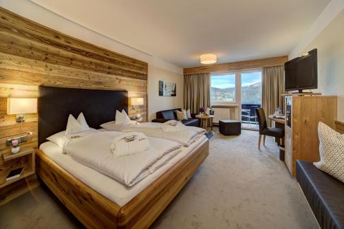 a hotel room with a large bed and a television at Wellnesshotel Hofbräuhaus in Bodenmais