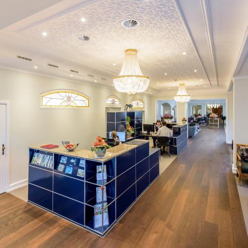 a lobby with blue cabinets and a chandelier at Kurhotel Im Park in Schinznach Bad