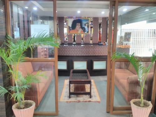 a room with two couches and a table with plants at Sai Pavilion in Puttaparthi