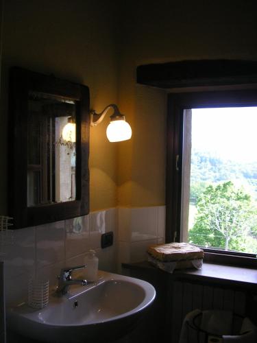 a bathroom with a sink and a mirror and a window at Casa Branzele in Trezzo Tinella