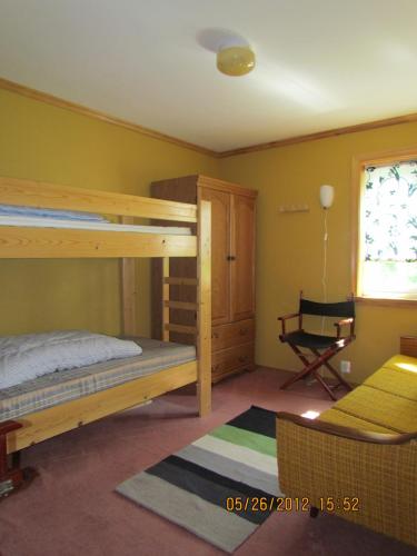 a bedroom with two bunk beds and a chair at Bondegårdsparken Farm Holiday in Kristiansand