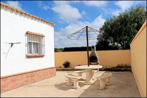 Un patio con una fuente y una ventana con una sombrilla. en Bungalow en complejo I, en Conil de la Frontera