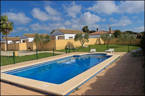 una piscina en un patio con una casa en Bungalow complejo III, en Conil de la Frontera