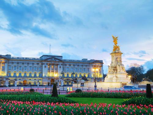 a building with a statue and flowers in front of it at easyHotel South Kensington in London