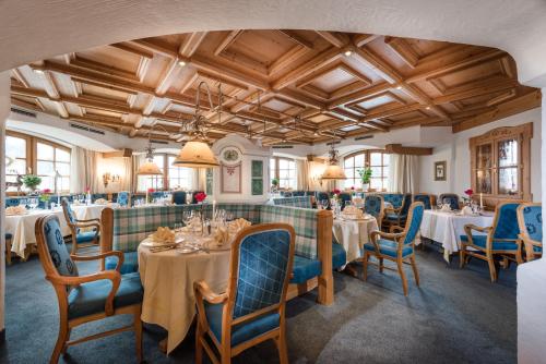 a dining room with tables and blue chairs at Alpines Lifestyle Hotel Tannenhof in Sankt Johann im Pongau