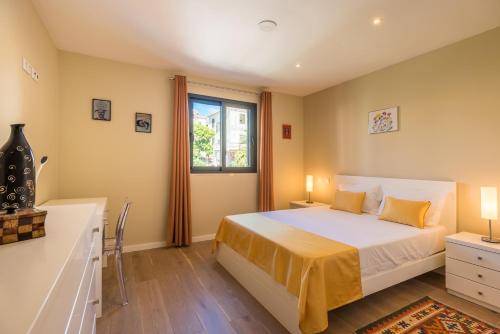 1 dormitorio con cama y ventana en Funchal SilverWood Apartment - by LovelyStay, en Funchal