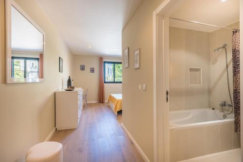 y baño con bañera, aseo y lavamanos. en Funchal SilverWood Apartment - by LovelyStay, en Funchal