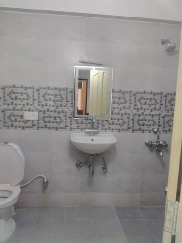 a bathroom with a sink and a toilet at Sai Pavilion in Puttaparthi