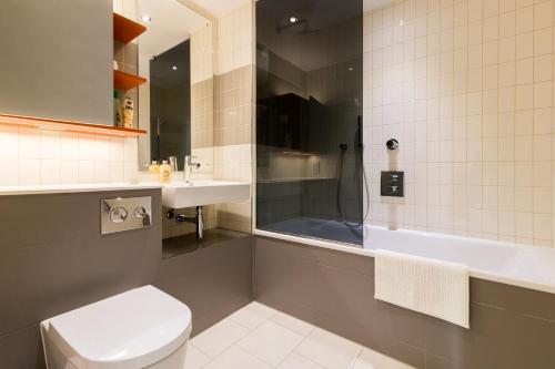 a bathroom with a shower and a toilet and a sink at Royal Style Apartment - 5 mins walk to ExCeL London in London