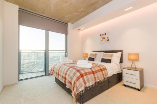 a bedroom with a bed and a large window at Royal Style Apartment - 5 mins walk to ExCeL London in London