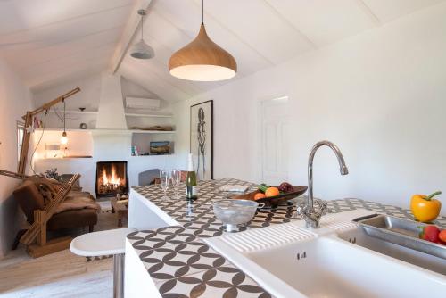 a kitchen and living room with a sink and a fireplace at La Careza De Mijas - Adults Only in Mijas