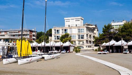 a group of boats on the sand in front of a building at Hotel Petit Palais in Venice-Lido