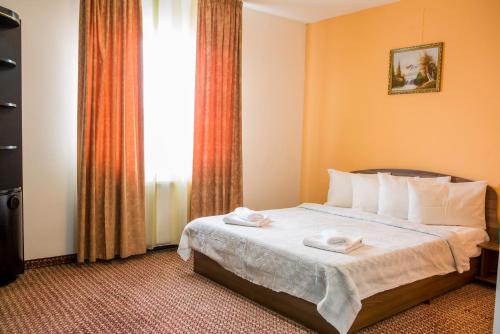 a hotel room with a bed with two towels on it at Hotel Darina in Târgu-Mureş