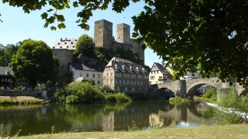 a bridge over a river with a castle in the background at Lahnhaus Brühl/ Fende Haus in Arfurt