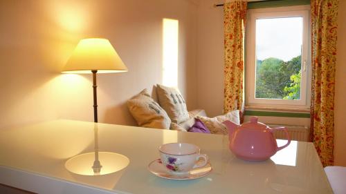 a table with a lamp and a tea pot on it at Lahnhaus Brühl/ Fende Haus in Arfurt