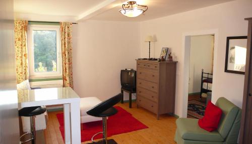a living room with a green chair and a dresser at Lahnhaus Brühl/ Fende Haus in Arfurt