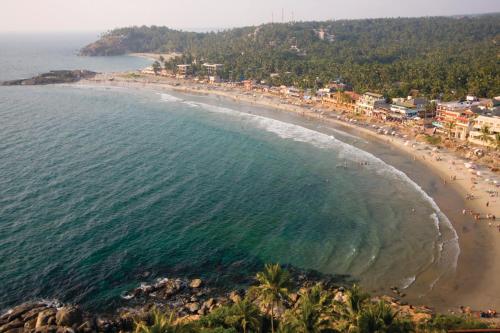 an aerial view of a beach with people and the ocean at Abad Harmonia Ayurvedic Beach Resort in Kovalam