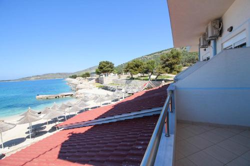 a balcony with a view of a beach with umbrellas at Hotel Artur in Ksamil