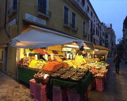 a market with fruits and vegetables on a street at Maison d'Ax Venice Center in Venice