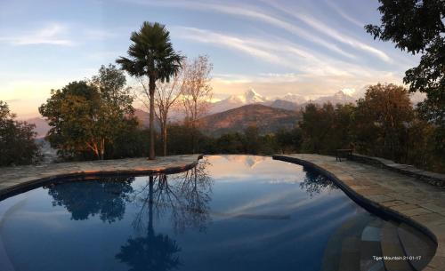 a swimming pool with a view of the mountains at Tiger Mountain Pokhara Lodge in Pokhara